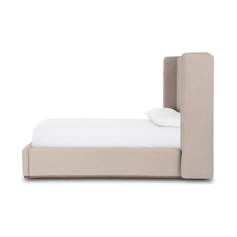 Here's a rewritten version of the sentence using the product data provided:

The Celeste Bed is displayed from the side, highlighting its tall, shelter-style headboard and beige upholstery. It stands on a natural wood plinth base with a low, rectangular frame. The bed is elegantly arranged with a white mattress and pillow, capturing modern minimalism against a white backdrop.