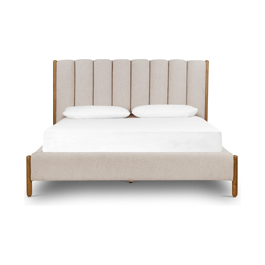 The Savannah Bed is a contemporary addition, showcasing a headboard upholstered in beige fabric with vertical panels and a smooth wooden frame. With its white mattress and pillows, it offers a sophisticated appearance that effortlessly coordinates with any modern bedroom decor.