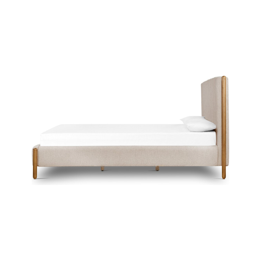 Here's a rewritten sentence using the given product data:

A side view of the Savannah Bed showcases its modern, minimalist design with a beige fabric frame complemented by wooden legs. The headboard is upholstered in matching beige fabric, and the bed features a white mattress and pillow, all set against a plain white background.