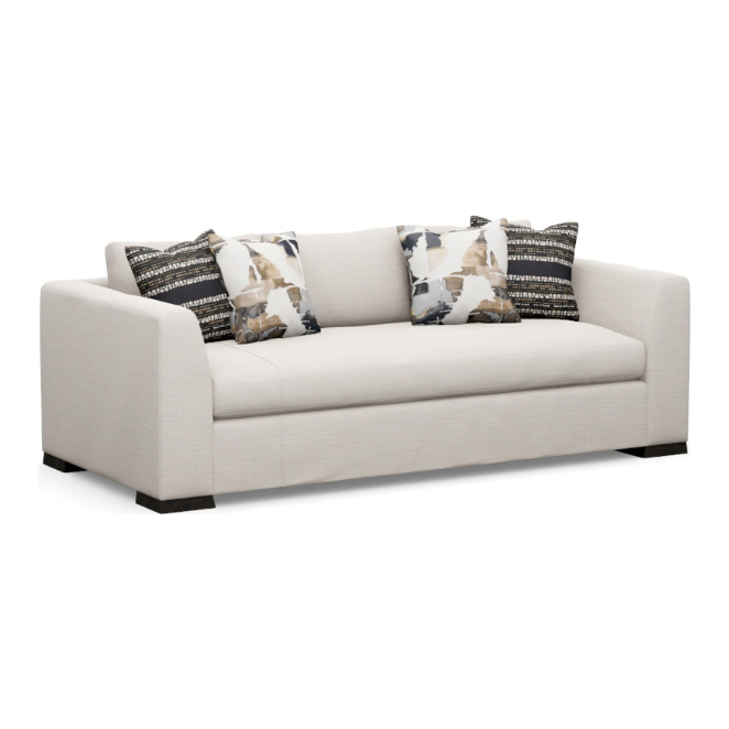 The Dresden Customizable Sofa, crafted by North Carolina artisans, offers a luxurious cream-colored design with clean lines and a sturdy frame. It comes with three decorative pillows: two featuring abstract patterns in black, white, and beige, and one adorned with horizontal black and white stripes. The sofa's look is finished off with rectangular armrests and dark brown block legs.
