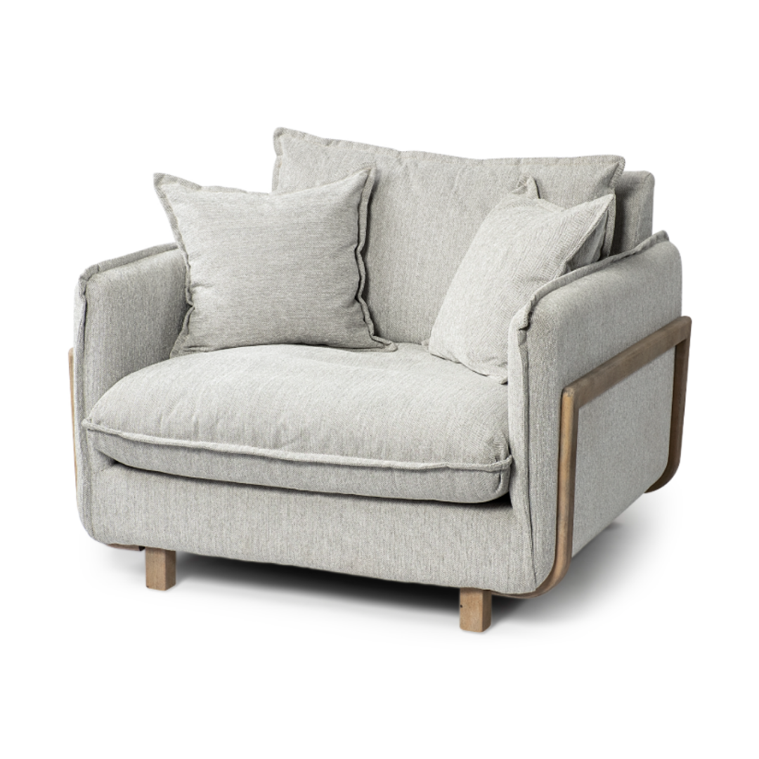 The Veyra Plush Upholstered Armchair in Frost Grey showcases modern luxury with its contemporary design. It includes a thick, cushioned seat and backrest, two matching throw pillows, sleek wooden armrests, and short wooden legs for a sturdy yet stylish appearance.