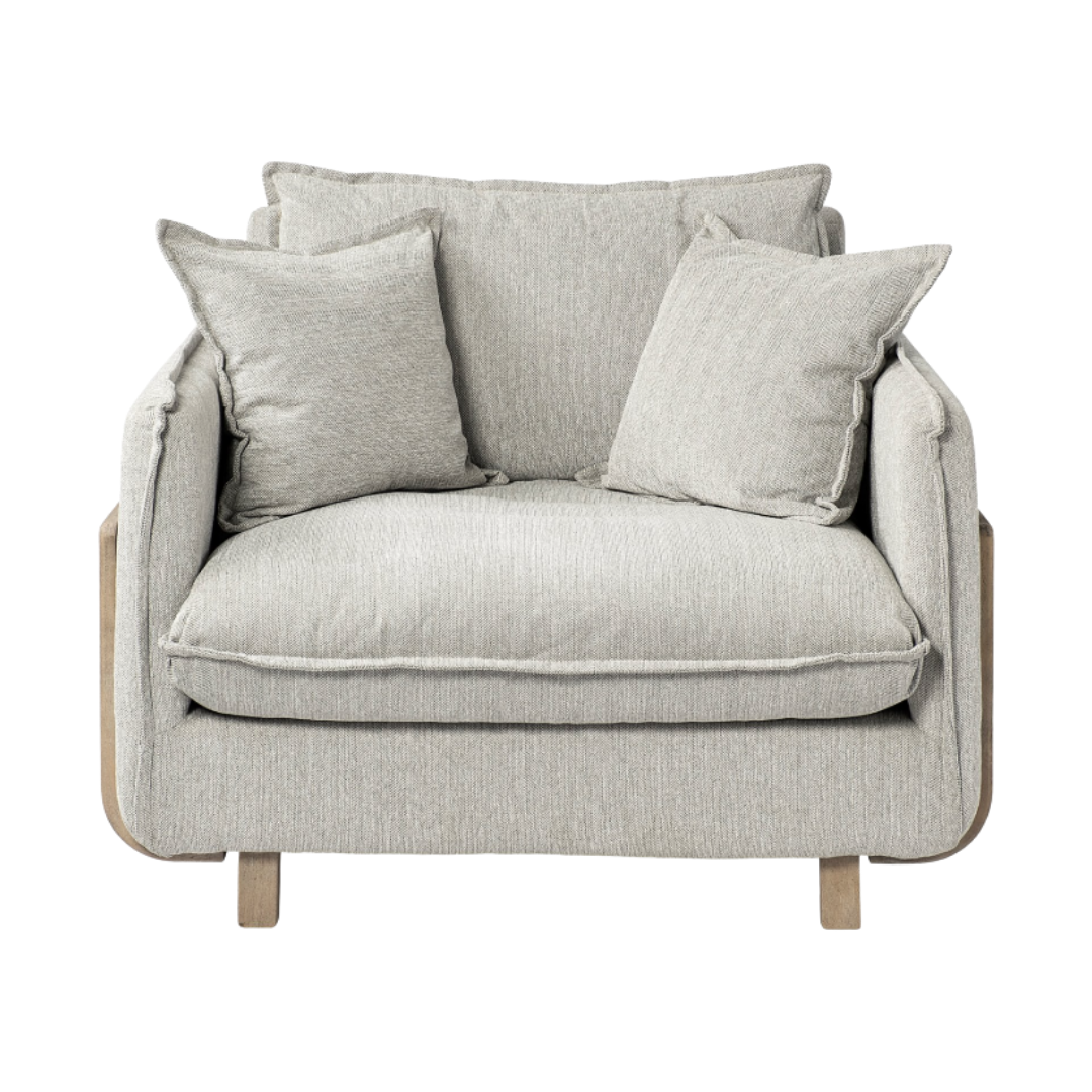 The Veyra Plush Upholstered Armchair in Frost Grey exudes modern luxury with matching pillows, a deep seat, and thick cushioning. Its light wood legs add to its sophisticated comfort, seamlessly blending style and ease against a plain white background.