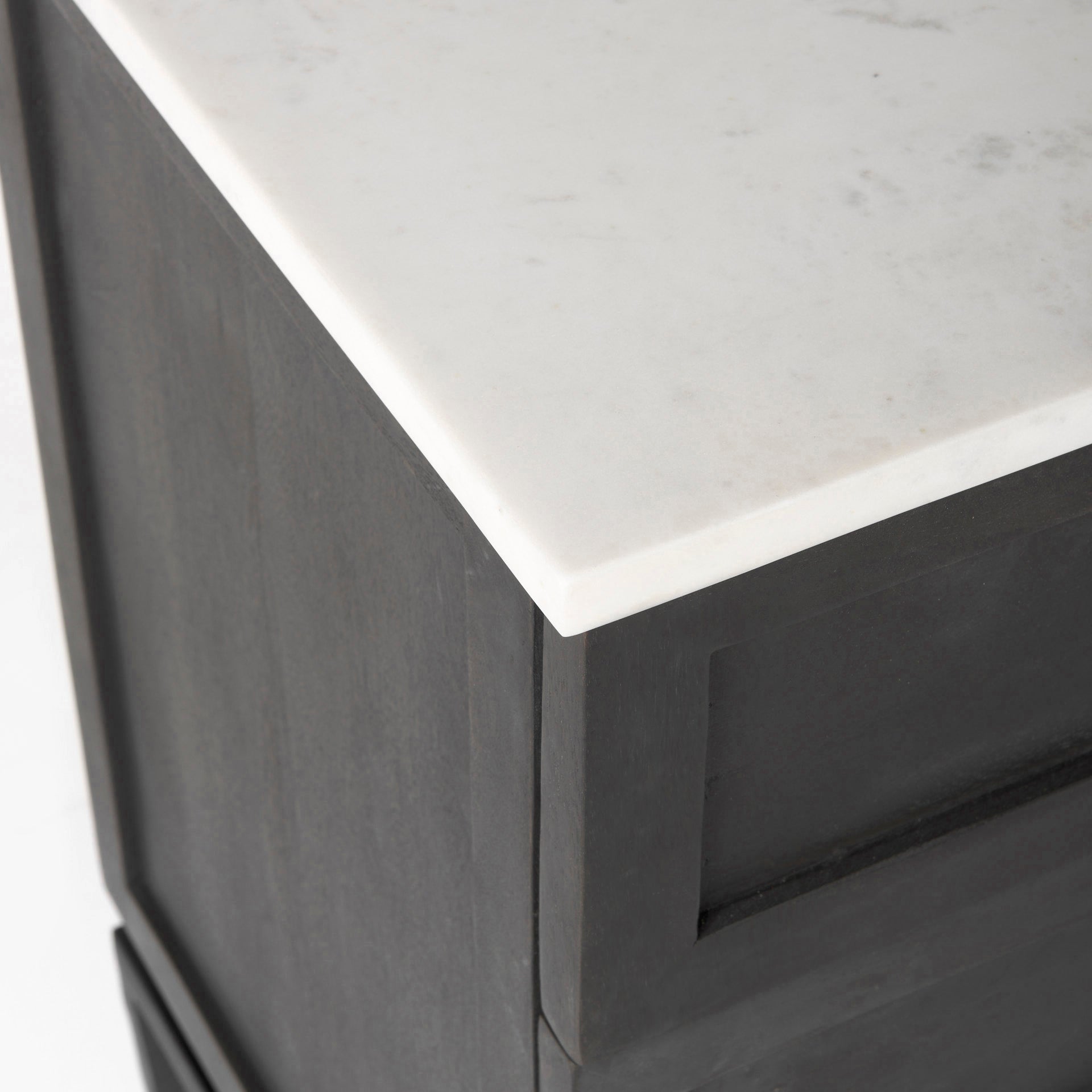 Close-up of a black cabinet with a white marble top