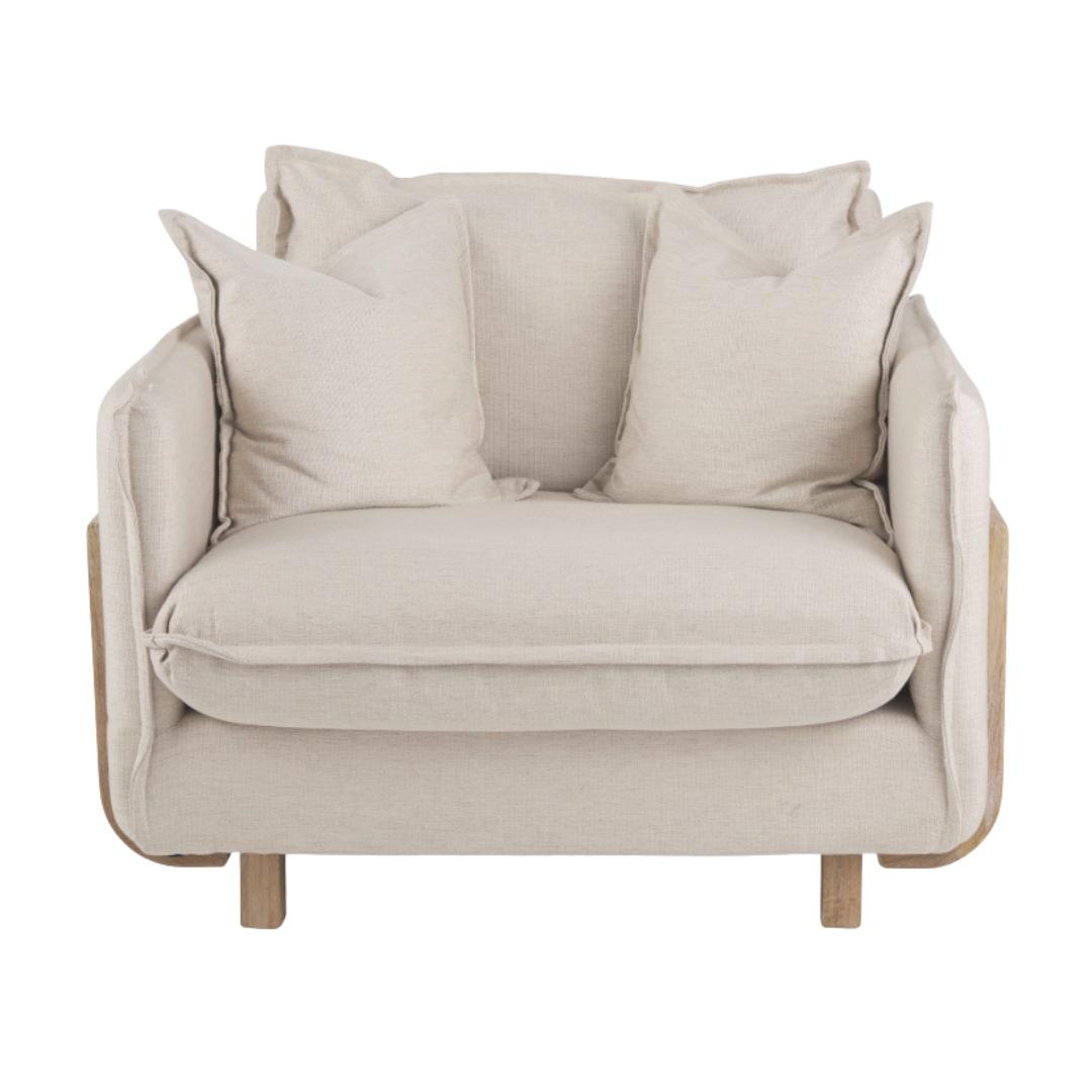 The Veyra Plush Upholstered Armchair in Beige features a cozy design with a wide seat, four soft pillows, and solid oak legs, making it perfect for living room seating.