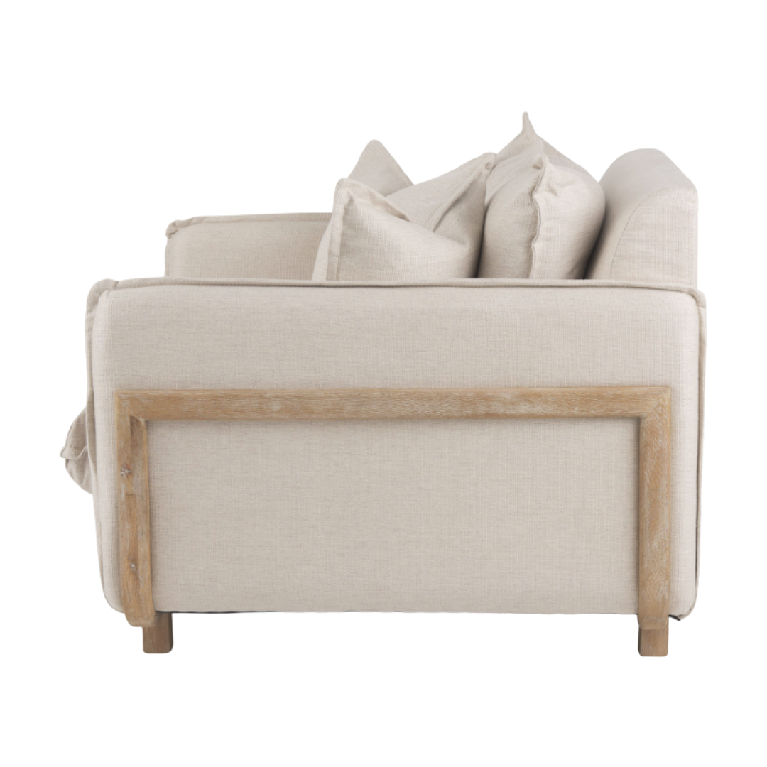 Side view of the Veyra Plush Upholstered Armchair in beige, showcasing plush comfort with thick cushions on the seat and backrest. The solid oak frame features a natural finish, visible on sides and base. Its simple, modern design offers three large cushions for additional support.