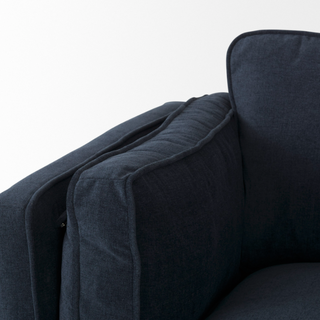 Close-up of the Zinnia Mid-Century Modern Navy Fabric Sofa's upper corner, highlighting its thick, cushioned back and side rests with visible seams and textured navy upholstery, set against a plain white background.