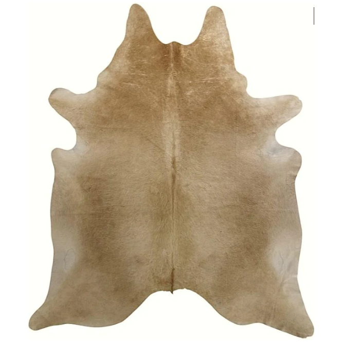 An overhead view of the Mini Hair-On Hide rug shows its symmetrical shape reminiscent of an animal hide, with slightly irregular edges. The texture is smooth, and the fur direction enhances the natural look. A central seam runs vertically, featuring a gradient effect in the coloring that adds depth to its light brown hue.
