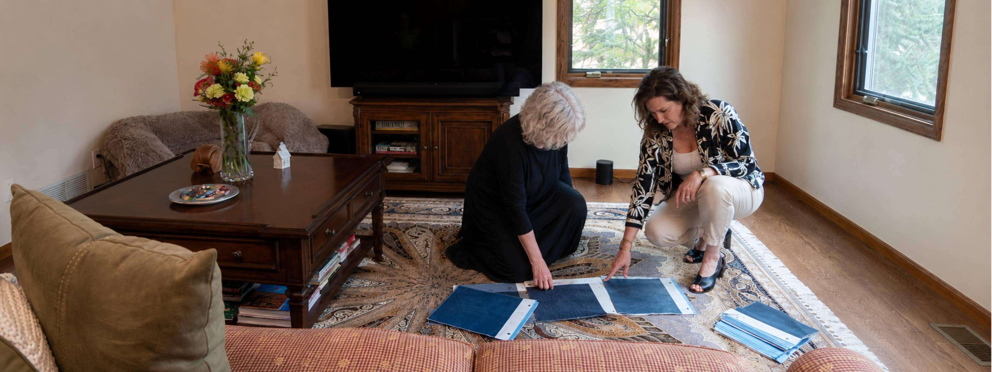 Professional interior designer helping a client choose fabrics for custom furniture in Fort Collins showroom