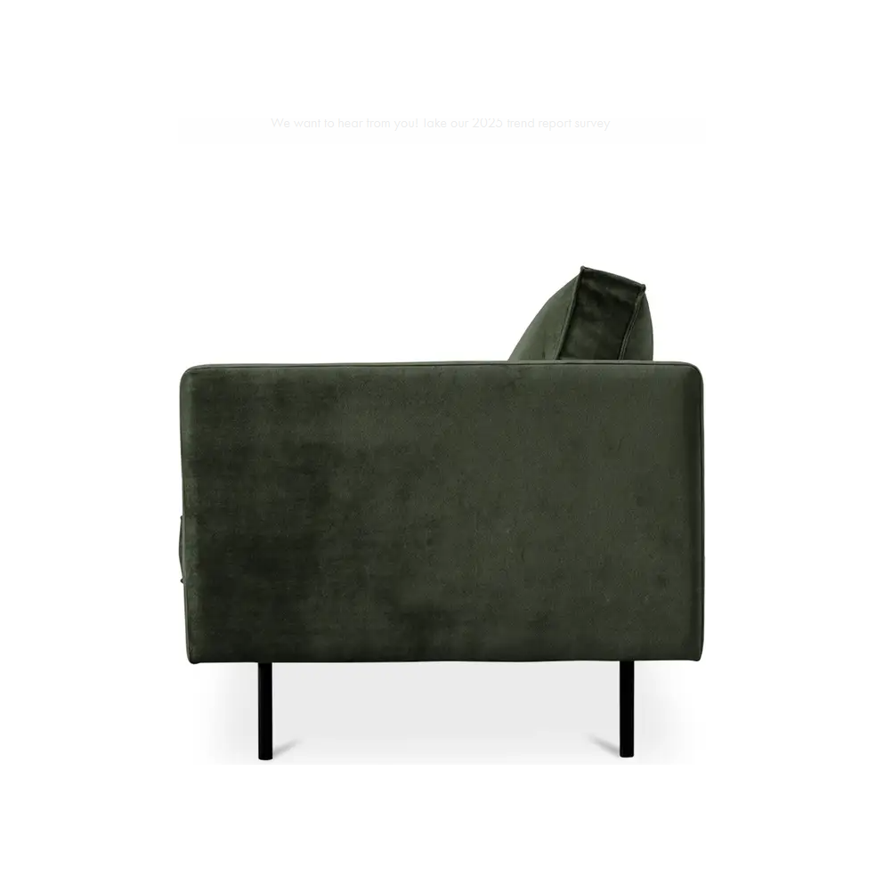 Side view of the Dixon Sofa in dark green polyester velvet, featuring minimalist black metal legs. This mid-century modern design has a sleek backrest and armrest, a seat cushion, clean lines, and textured fabric against a plain white background.