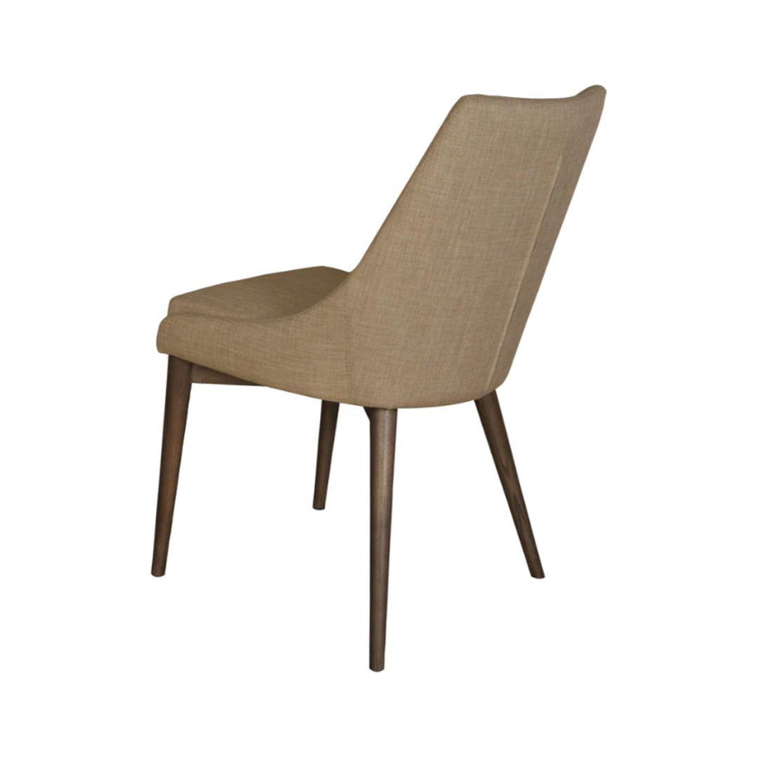 The Franny Dining Chair in Beige features a modern design with neutral fabric upholstery on both the seat and backrest. It is enhanced by sleek, angled dark ash wood legs and a slightly reclined back for added comfort, making it an ideal addition to contemporary interiors.