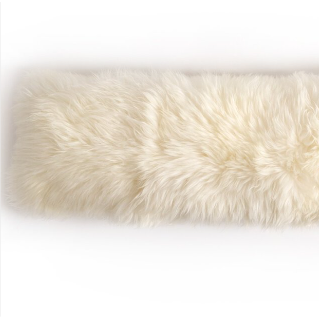 A rectangular, fluffy white sheepskin rug with a soft and thick texture. The rug’s wool appears plush and dense, providing a cozy and luxurious appearance reminiscent of the Lambskin Lumbar Pillow. The background is plain white, highlighting the rug's soft details and texture.