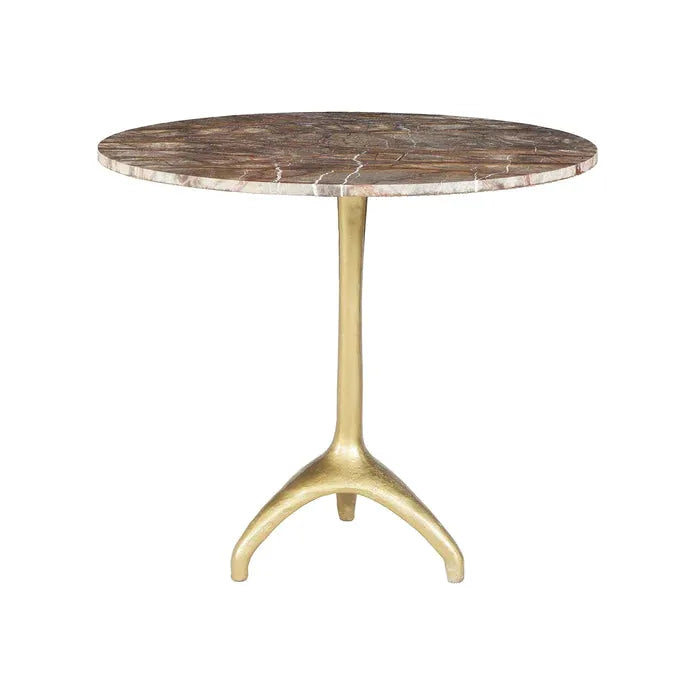 A round Sierra Café Table with an antique-finished Bidasar Brown Marble top featuring a mosaic pattern in various shades of brown and beige. The table is supported by a sleek, brass-finished cast-iron base with three legs. The overall design is elegant and modern, suitable for dining or accent purposes.