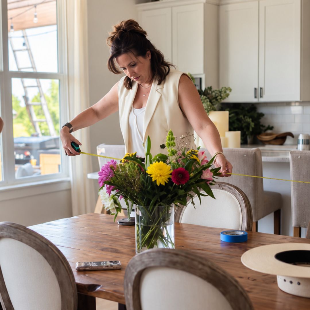 Interior designer Jaime Cawthron takes measurements in a client’s dining area for an in-home design plan.