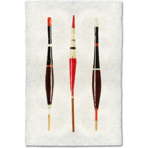 Three Vintage Floats (1) are arranged vertically in a row against a plain white background. The floats, resembling unique images crafted on handmade paper, have elongated, slender bodies with varied colors, including black, red, and white. Each float displays distinct markings and color patterns.