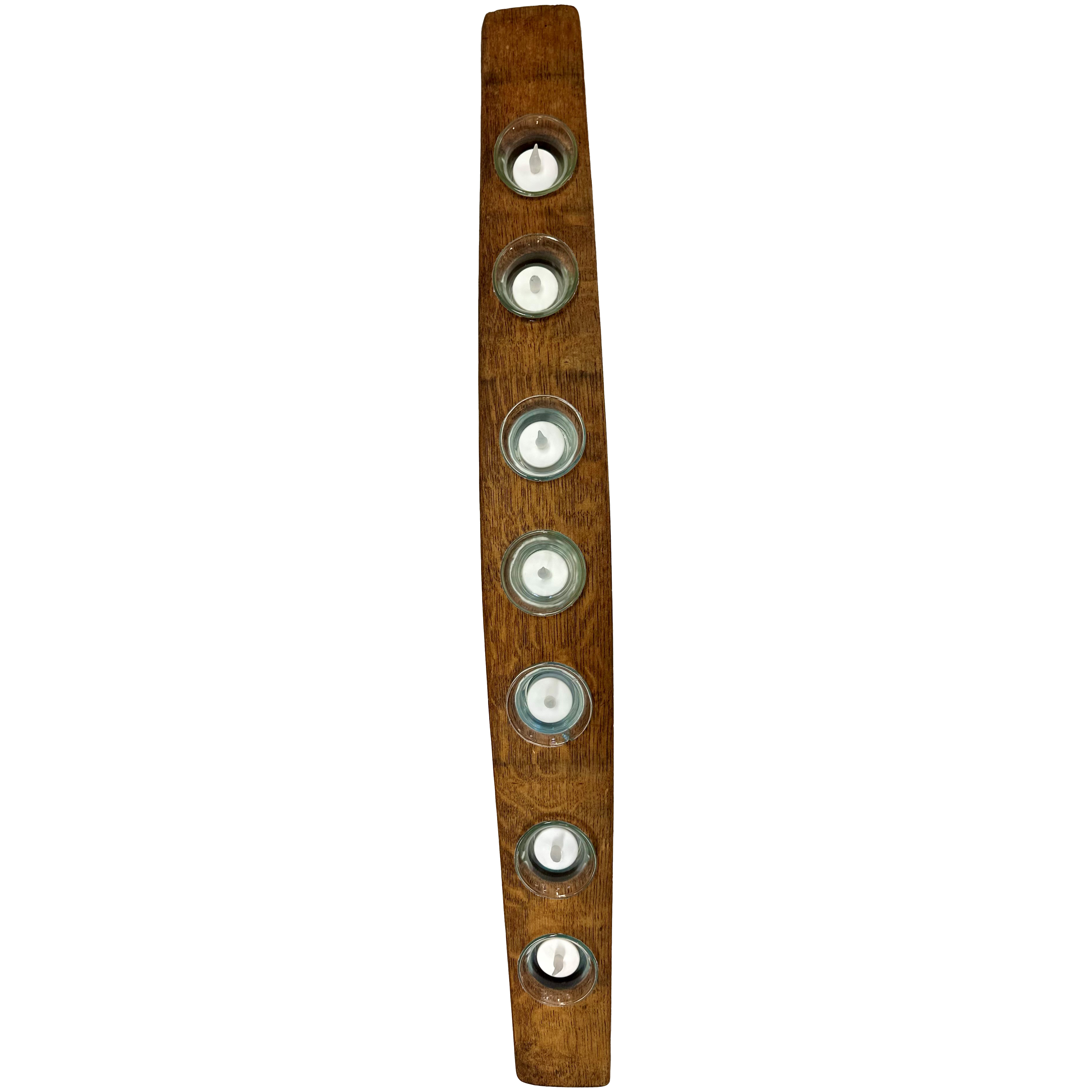 The Wine Barrel Candle Holder is meticulously crafted from a repurposed wine barrel stave, accommodating seven evenly spaced round tea light candles in metal holders along its curved design. The wood displays a rich, warm finish that elegantly highlights its grain and natural texture.