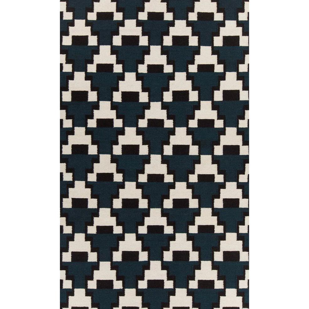 The Avon Wool Rug features a geometric pattern of black, dark green, and white stepped shapes in pixelated cross motifs. This repeating design creates a bold, high-contrast mosaic effect for a modern look on a rectangular rug surface.