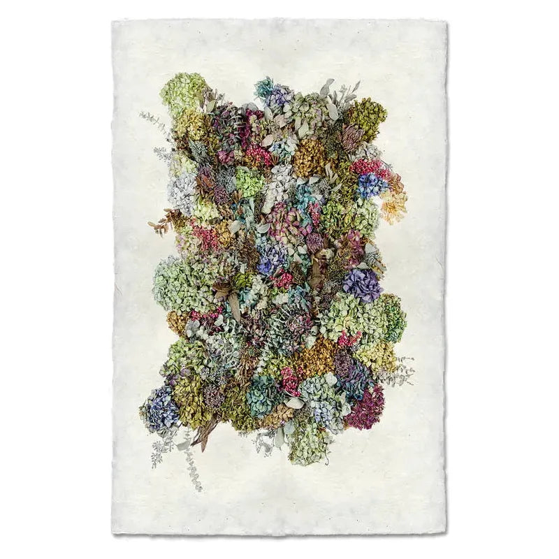The Grand, Hydrangeas Collective is a textured art piece showcasing an intricate collage of dried flowers in vibrant hues such as green, purple, blue, and pink. These flowers are densely packed on a background that resembles handmade photograph paper, embodying archival quality with its rich tapestry set against an elegant backdrop.