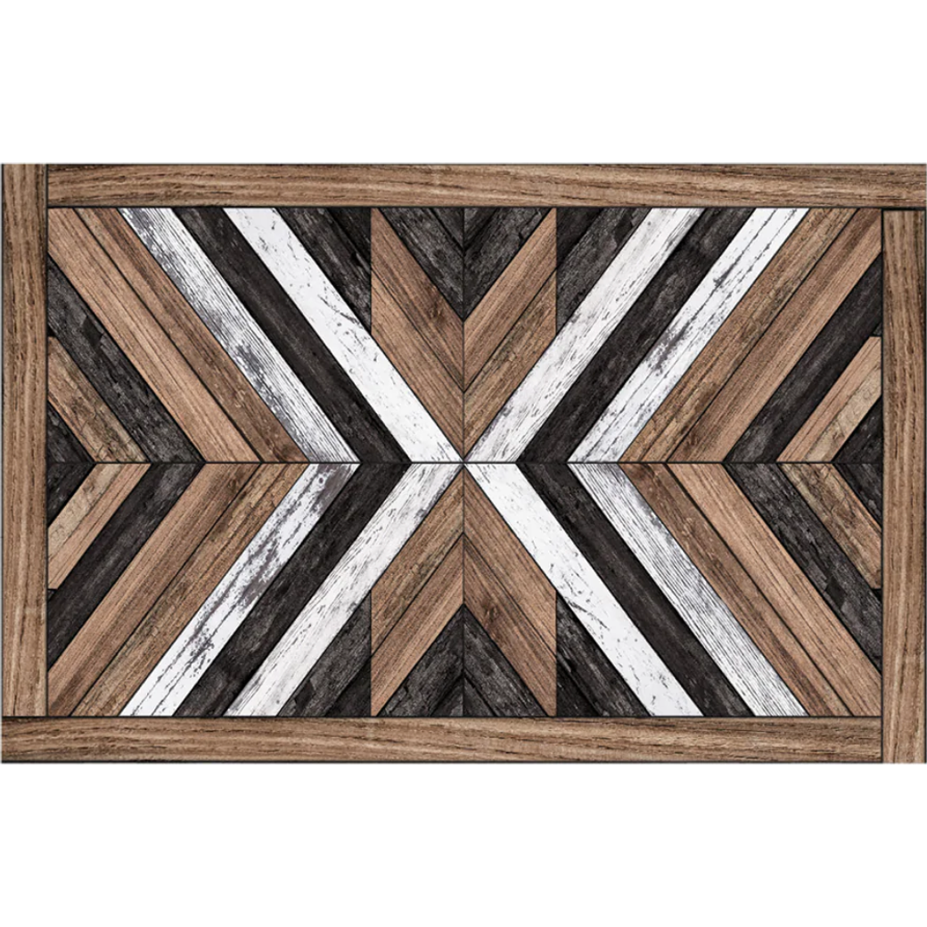 The Wood Art Vinyl Placemat features a rectangular, stain-resistant surface with a geometric chevron pattern in brown, black, white, and gray wood textures forming a central X and is finished with a matching brown wood border.