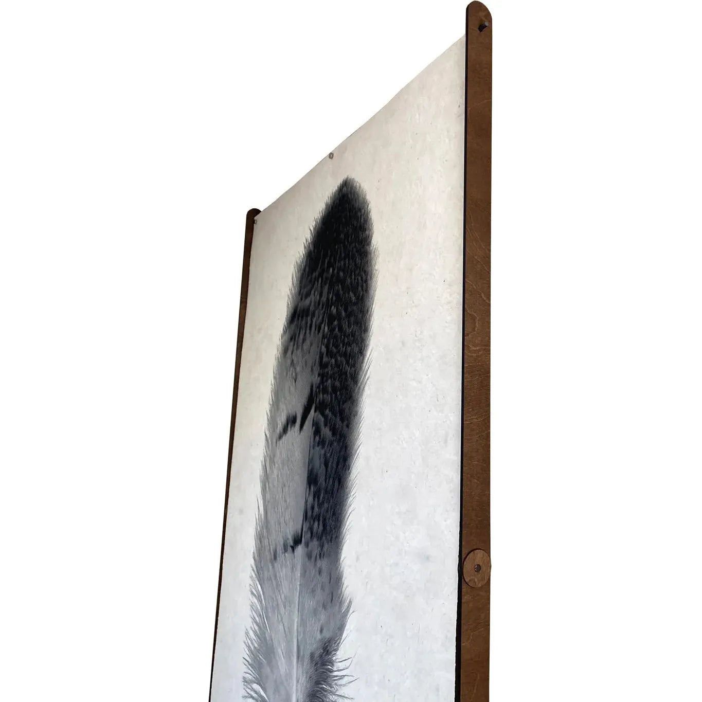 Side view of framed wall art featuring a detailed black and white feather on a white background. The simple wooden frame, with visible wood grain, uses Frameless Wood/Steel Hanger, Straight for secure mounting. Two round pegs at each corner add charm while ensuring no damage to the print, highlighting intricate patterns in the feather.
