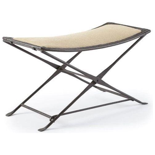 The Addison Bench is a modern folding burlap bench with a minimalist design, featuring an X-leg base and rectangular seat. The light beige fabric contrasts beautifully with the dark frame, offering sleek, industrial extra seating for contemporary interiors.