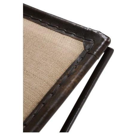 Close-up of the corner of an Addison Bench, featuring a metal frame with a dark finish. The frame surrounds a beige fabric panel, secured with visible stitching along the edges. A thin, cylindrical metal support extends from the corner, suggesting part of an X-leg base for extra seating.