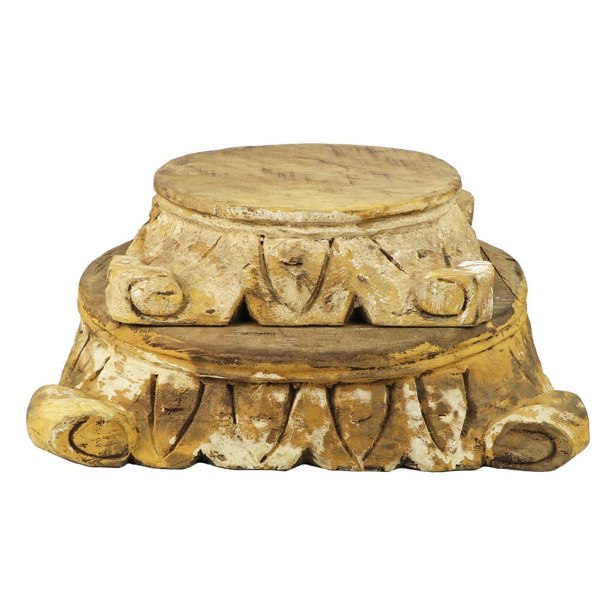 The Carved Pillar Base in natural wood features a round top, intricate leaf patterns, and a weathered finish. Its smaller top creates a tiered effect, while the rustic, golden-brown wood with distressed white accents adds vintage charm.