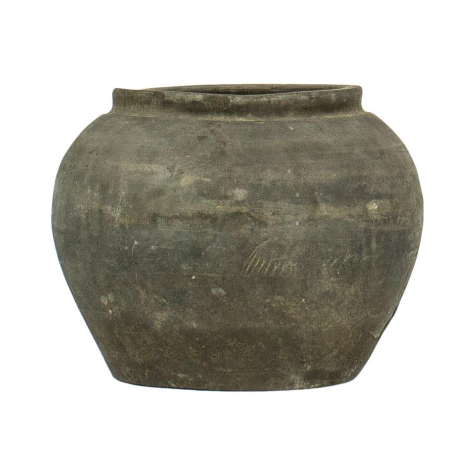 The Cunmin Pot, a weathered dark gray terracotta piece with a rounded body and slightly narrow opening, exudes a vintage charm. Its subtly textured surface shows faint scratches hinting at historical crafting methods. Perfect for décor, it is displayed on a plain white background.
