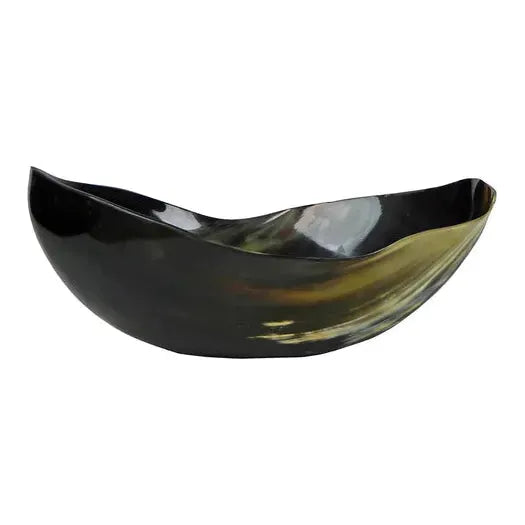 The Cow Horn Bowl is an irregularly shaped black bowl with a smooth, glossy finish, featuring a stylish wavy rim and a subtle blend of dark shades. Hints of greenish-yellow reflections dance on its surface, reminiscent of natural accents from cow horns, adding to its elegant and artistic appearance.