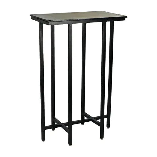 The Liora Martini Table is a tall, slim, narrow black metal side table with sleek aluminum plating. It features a flat top and four vertical legs connected by crossbars at the bottom, creating a sturdy, minimalist look perfect for modern or industrial-style interiors.