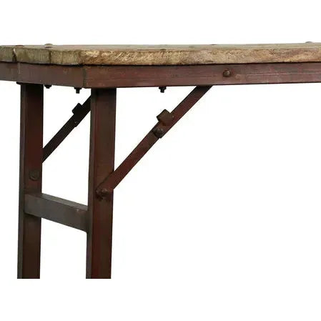 Close-up of the Wedding Table’s corner, featuring a thick, weathered wooden top and sturdy, dark reddish-brown metal legs with visible bolts and a diagonal brace for added stability. The table is showcased against a white background.
