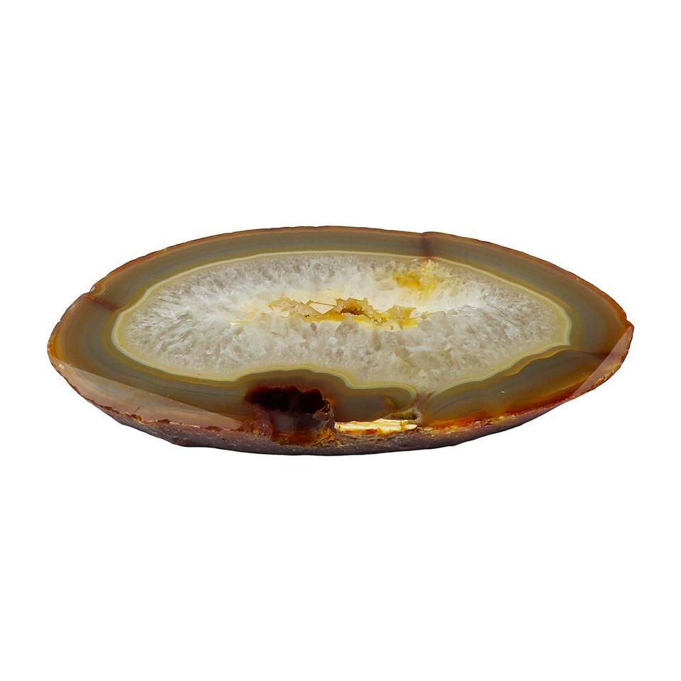 The Thick Agate Slab, a polished slice of Brazilian agate, showcases natural colors in concentric layers of varying brown, tan, and white shades. The outermost layer features a dark brown hue that gradually transitions to lighter tones toward the center. The middle is predominantly white and crystalline with rough and uneven edges.