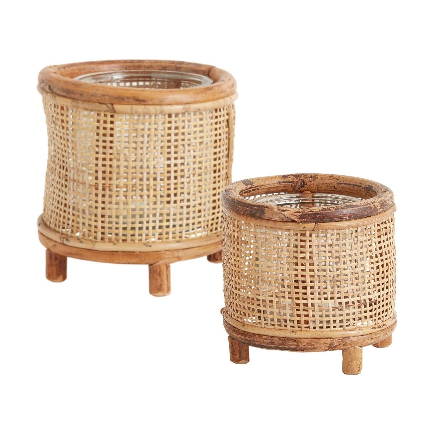 Two round, Wicker Candleholders in different sizes are displayed. Each holder boasts a cylindrical shape with woven wicker walls, wooden top and bottom edges, and three short wooden legs. The larger Wicker Candleholder is positioned slightly behind and to the left of the smaller one.
