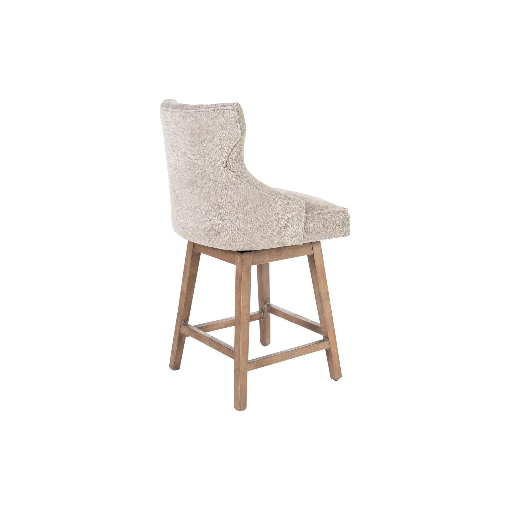 The Letty Swivel Counter Stool features a cushioned seat and backrest upholstered in modern gray polyblend fabric. The backrest boasts a subtle winged design. Its legs are crafted from gray-washed oak, connected by horizontal support bars doubling as footrests, giving it a classic and elegant appearance.
